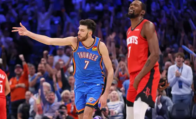Oklahoma City Thunder center Chet Holmgren, left, celebrates after making a shot near Houston Rockets forward Kevin Durant, right, during the first overtime of an NBA basketball game Tuesday, Oct. 21, 2025, in Oklahoma City. (AP Photo/Nate Billings)