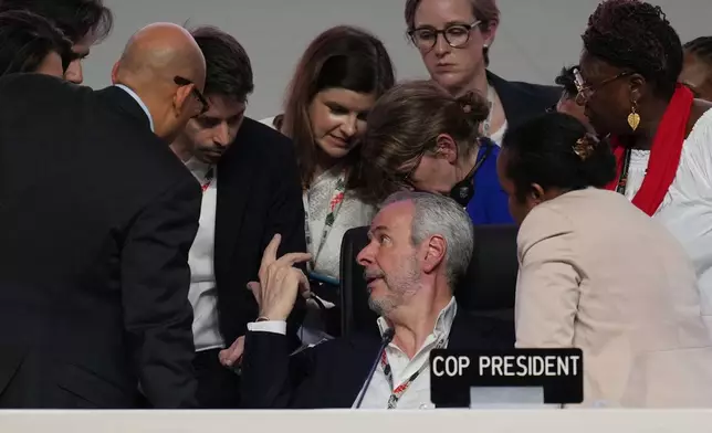 André Corrêa do Lago, COP30 president, center, and Simon Stiell, United Nations climate chief, front left, speak with staff during a plenary session at the COP30 U.N. Climate Summit, Saturday, Nov. 22, 2025, in Belem, Brazil. (AP Photo/Andre Penner)