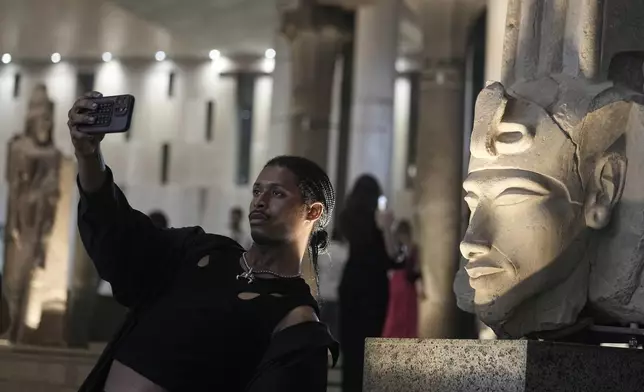 A tourist takes a selfie in front of Akhenaten statue during his visit to the Grand Egyptian Museum in Giza, Egypt, Friday, May 23, 2025. (AP Photo/Amr Nabil)