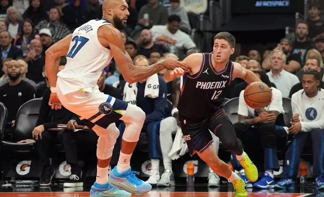 Phoenix Suns guard Collin Gillespie, right, drives past Minnesota Timberwolves center Rudy Gobert (27) during the first half of an NBA Cup basketball game, Friday, Nov. 21, 2025, in Phoenix. (AP Photo/Rick Scuteri)