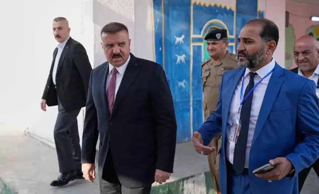 Iraq's Interior Minister Abdul Amir al-Shammari, center, visits one of the polling centers during a special voting session ahead of Tuesday's parliamentary election in Baghdad, Iraq, Sunday, Nov. 9, 2025. (AP Photo/Hadi Mizban)