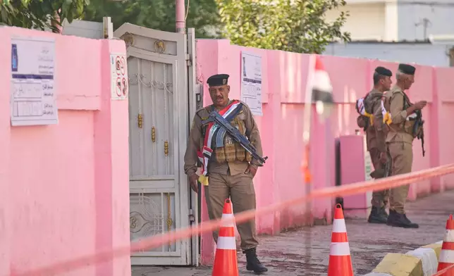 Security forces stand guard outside a polling station during a special voting session ahead of Tuesday's parliamentary election in Baghdad, Iraq, Sunday, Nov. 9, 2025. (AP Photo/Hadi Mizban)