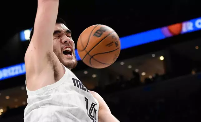 Memphis Grizzlies center Zach Edey dunks in the first half of an NBA basketball game against the Sacramento Kings, Thursday, Nov. 20, 2025, in Memphis, Tenn. (AP Photo/Brandon Dill)