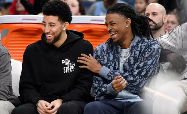 Memphis Grizzlies guards Scotty Pippen Jr., left, and Ja Morant, right, react from the bench in the first half of an NBA basketball game against the Sacramento Kings, Thursday, Nov. 20, 2025, in Memphis, Tenn. (AP Photo/Brandon Dill)