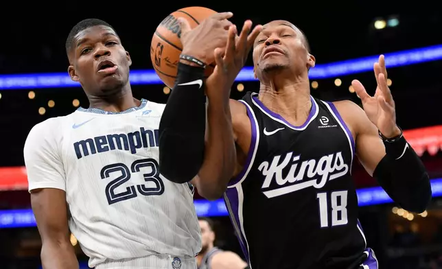 Memphis Grizzlies forward Cedric Coward (23) and Sacramento Kings guard Russell Westbrook (18) battle for control of the ball in the first half of an NBA basketball game Thursday, Nov. 20, 2025, in Memphis, Tenn. (AP Photo/Brandon Dill)