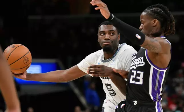 Memphis Grizzlies guard Vince Williams Jr. (5) handles the ball against Sacramento Kings guard Keon Ellis (23) in the first half of an NBA basketball game Thursday, Nov. 20, 2025, in Memphis, Tenn. (AP Photo/Brandon Dill)