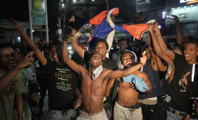 Fans celebrate Haiti's qualification for the 2026 FIFA World Cup after a soccer match against Nicaragua, in Port-au-Prince, Haiti, Tuesday, Nov. 18, 2025. (AP Photo/Odelyn Joseph)