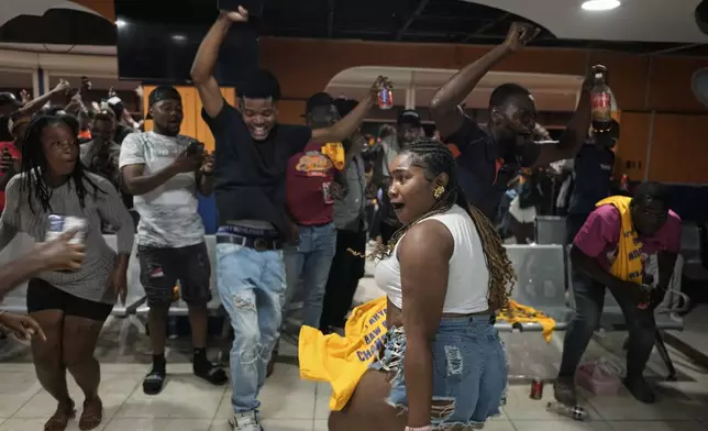 Fans watching a 2026 FIFA World Cup qualifying match between Haiti and Nicaragua celebrate Haiti's second goal, in Port-au-Prince, Haiti, Tuesday, Nov. 18, 2025. (AP Photo/Odelyn Joseph)