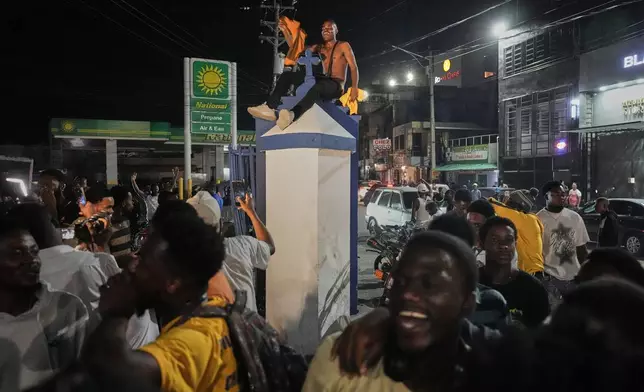 Fans celebrate Haiti's qualification for the 2026 FIFA World Cup after a soccer match against Nicaragua, in Port-au-Prince, Haiti, Tuesday, Nov. 18, 2025. (AP Photo/Odelyn Joseph)