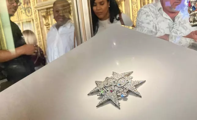 FILE - Visitors look at jewelry in the Apollo Gallery of the Louvre museum on Sept. 4, 2025, in Paris. (AP Photo/Alexander Turnbull, File)