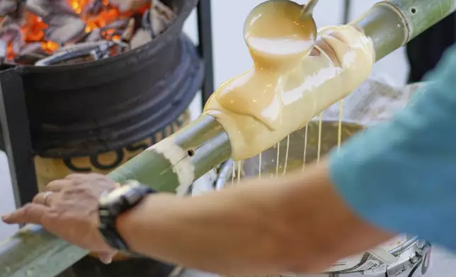 Staff make Baumkuchen, a German layered cake, during a workshop of Juchheim Ninoshima Welcome Center and Outdoor Activity Camp Monday, July 7, 2025, at Ninoshima island in Hiroshima, western Japan. (AP Photo/Eugene Hoshiko)
