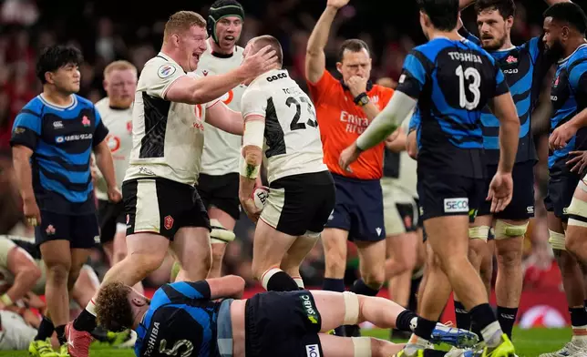 Wales' Nick Tompkins, center, celebrates with a teammate after scoring a try during the rugby union Nations Series match between Wales and Japan at the Principality Stadium, Cardiff, Saturday, Nov. 15, 2025. (Andrew Matthews/PA via AP)