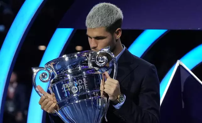 Spain's Carlos Alcaraz kisses the trophy for finishing the year ranked No. 1 as ATP world best player during the ATP World Tour Finals, in Turin, Italy, Friday, Nov. 14, 2025. (AP Photo/Antonio Calanni)