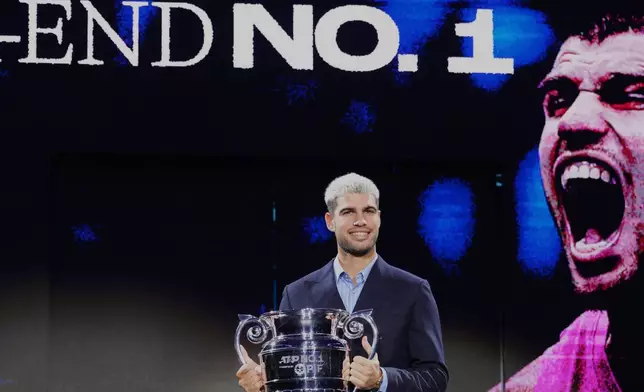 Spain's Carlos Alcaraz holds the trophy for finishing the year ranked No. 1 as ATP world best player during the ATP World Tour Finals, in Turin, Italy, Friday, Nov. 14, 2025. (AP Photo/Antonio Calanni)