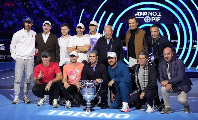 Spain's Carlos Alcaraz poses with his team as he holds the trophy for finishing the year ranked No. 1 as ATP world best player during the ATP World Tour Finals, in Turin, Italy, Friday, Nov. 14, 2025. (AP Photo/Antonio Calanni)