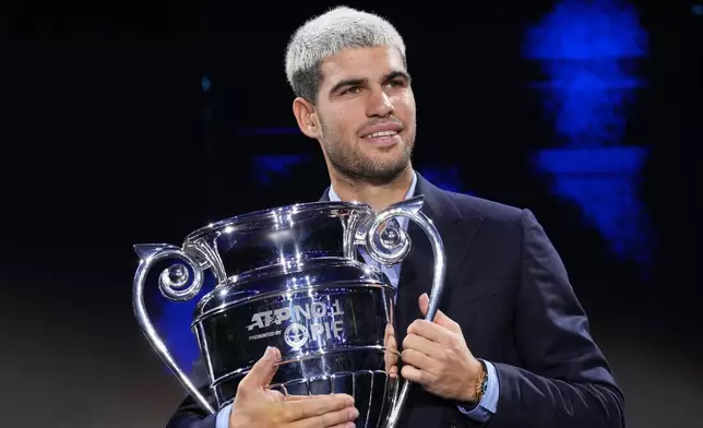 Spain's Carlos Alcaraz holds the trophy for finishing the year ranked No. 1 as ATP world best player during the ATP World Tour Finals, in Turin, Italy, Friday, Nov. 14, 2025. (AP Photo/Antonio Calanni)
