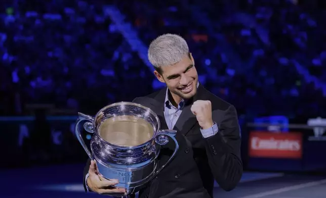 Spain's Carlos Alcaraz holds the trophy for finishing the year ranked No. 1 as ATP world best player during the ATP World Tour Finals, in Turin, Italy, Friday, Nov. 14, 2025. (AP Photo/Antonio Calanni)