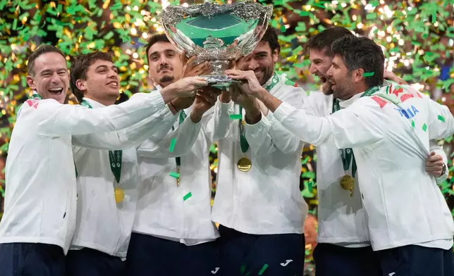 Italian tennis team members hold the Davis Cup trophy after the final between Italy and Spain, in Bologna, Italy, Sunday, Nov. 23, 2025. (AP Photo/Luca Bruno)