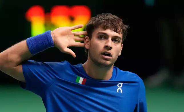 Italy's Flavio Cobolli celebrates after winning a point against Spain's Jaume Munar during a Davis Cup final singles tennis match between Italy and Spain, in Bologna, Italy, Sunday, Nov. 23, 2025. (AP Photo/Luca Bruno)