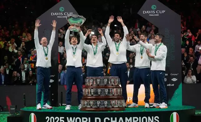 Italian tennis team members hold the Davis Cup trophy after the final between Italy and Spain, in Bologna, Italy, Sunday, Nov. 23, 2025. (AP Photo/Luca Bruno)
