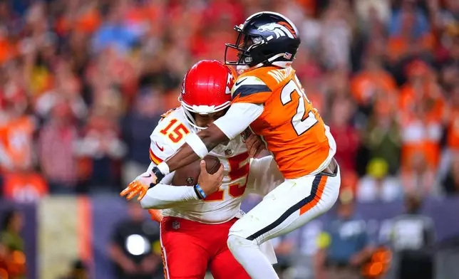 Denver Broncos cornerback Ja'Quan McMillian, right, sacks Kansas City Chiefs quarterback Patrick Mahomes (15) during the second half an NFL football game Sunday, Nov. 16, 2025, in Denver. (AP Photo/Jack Dempsey)