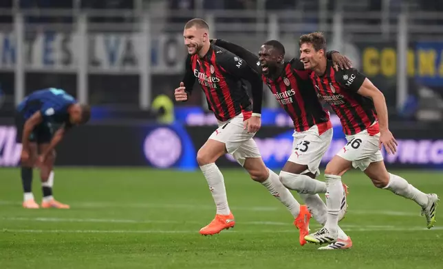 From the left, AC Milan's Strahinja Pavlovic, Fikayo Tomori, and Matteo Gabbia celebrate after the Serie A soccer match between Inter Milan and AC Milan in Milan, Italy, Sunday, Nov. 23, 2025. (AP Photo/Antonio Calanni)