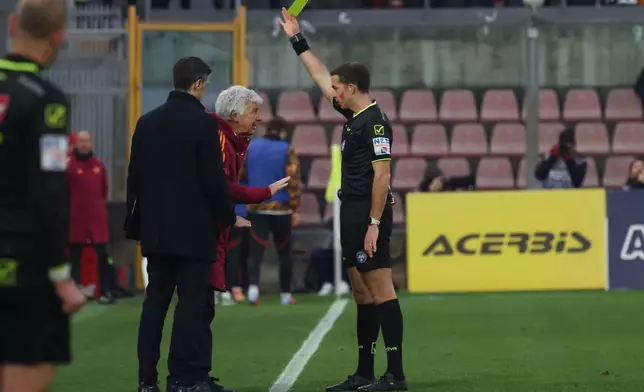 Referee Giovanni Ayroldi shows a yellow card to Roma's head coach Gian Piero Gasperini during the Italian Serie A soccer match between Cremonese and Roma in Cremona, Italy, Sunday, Nov. 23, 2025. (Alberto Mariani/LaPresse via AP)