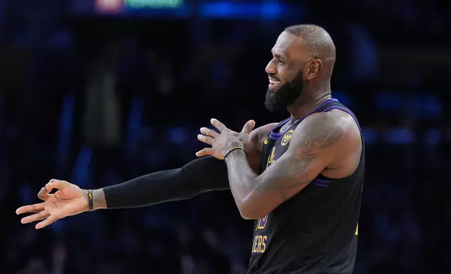 Los Angeles Lakers forward LeBron James (23) reacts to a three-point basket by guard Gabe Vincent during the second half of an NBA basketball game against the Utah Jazz Tuesday, Nov. 18, 2025, in Los Angeles. (AP Photo/Jae C. Hong)