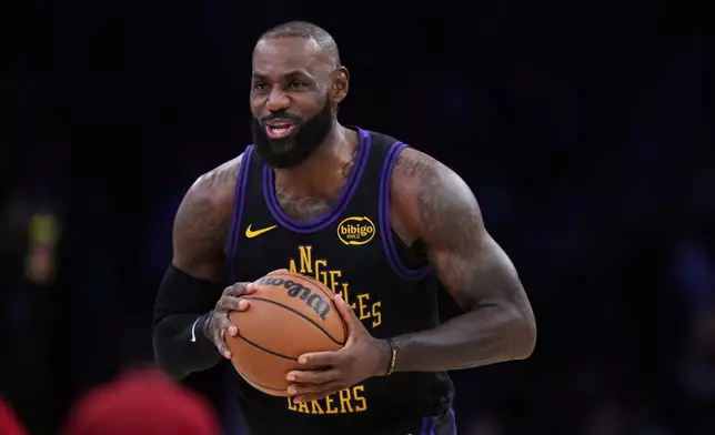 Los Angeles Lakers forward LeBron James (23) holds the ball before the tip-off during the first half of an NBA basketball game against the Utah Jazz Tuesday, Nov. 18, 2025, in Los Angeles. (AP Photo/Jae C. Hong)