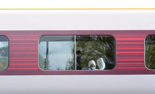Forensic investigators are seen at the train after a mass stabbing on a London-bound train in Huntingdon, England, Sunday, Nov. 2, 2025.(AP Photo/Kirsty Wigglesworth)