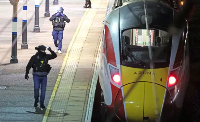 Police on the platform by the train at Huntingdon station after a mass stabbing on a London-bound train in eastern England, in Cambridgeshire, England, Saturday, Nov. 1, 2025. (Chris Radburn/PA via AP)