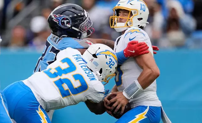 Los Angeles Chargers quarterback Justin Herbert (10) is sacked by Titans linebacker Cedric Gray (33) of an NFL football game Sunday, Nov. 2, 2025, in Nashville, Tenn. (AP Photo/George Walker IV)
