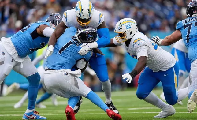 Tennessee Titans quarterback Cam Ward (1) is sacked by Los Angeles Chargers linebacker Odafe Oweh (98) during the second half of an NFL football game Sunday, Nov. 2, 2025, in Nashville, Tenn. (AP Photo/George Walker IV)