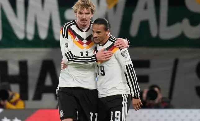 Germany's Nick Woltemade, left, and Leroy Sané hug after scoring during a group A World Cup qualifiying soccer match between Germany and Slovakia in Leipzig, Germany, Monday, Nov. 17, 2025. (AP Photo/Matthias Schrader)