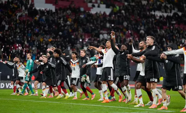 German players celebrate qualifying for the World Cup after beating Slovakia in Leipzig, Germany, Monday, Nov. 17, 2025. (AP Photo/Matthias Schrader)