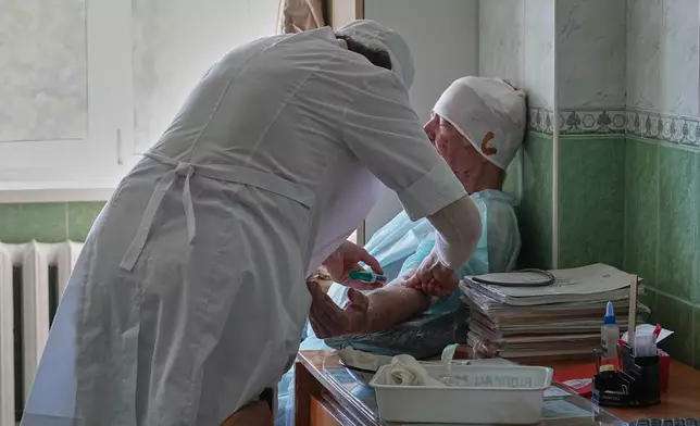 A wounded local resident gets treatment at one of the city main hospitals treating drone victims in the frontline city of Kherson, Southern Ukraine, Monday, Nov. 3, 2025. (AP Photo/Efrem Lukatsky)