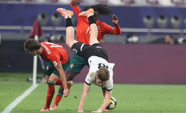 Austria's Luca Weinhandl falls in front of Portugal's Stevan during the FIFA U17 World Cup final soccer match between Portugal and Austria in Doha, Qatar, on Thursday, Nov. 27, 2025. (AP Photo/Hussein Sayed)