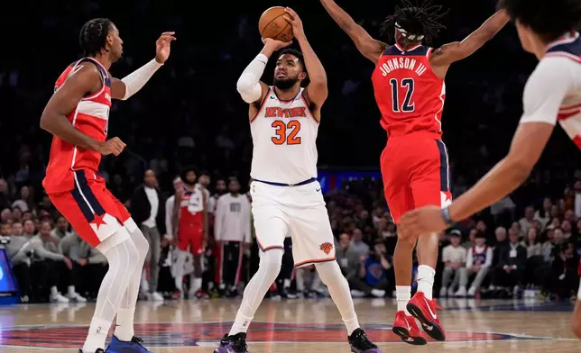 New York Knicks center Karl-Anthony Towns (32) shoots during the first half of an NBA basketball game, Monday, Nov. 3, 2025, in New York. (AP Photo/Yuki Iwamura)