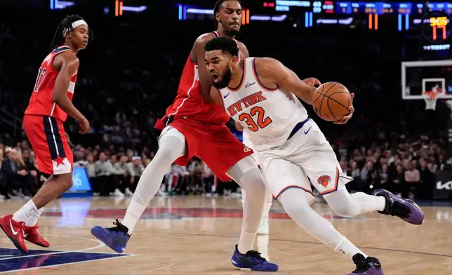 New York Knicks center Karl-Anthony Towns (32) drives past Washington Wizards center Alex Sarr (20) during the first half of an NBA basketball game, Monday, Nov. 3, 2025, in New York. (AP Photo/Yuki Iwamura)