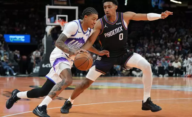 Utah Jazz guard Keyonte George drives on Phoenix Suns forward Ryan Dunn (0) during the second half of an NBA Cup basketball game, Friday, Oct. 31, 2025, in Phoenix. (AP Photo/Rick Scuteri)