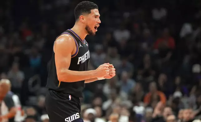 Phoenix Suns guard Devin Booker reacts after scoring against the Utah Jazz during the first half of an NBA basketball game, Friday, Oct. 31, 2025, in Phoenix. (AP Photo/Rick Scuteri)