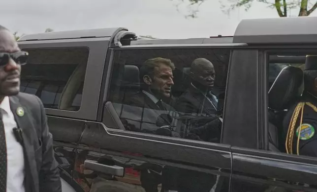 France's President Emmanuel Macron, left, and Gabon's President Brice Oligui Nguema, are seen as their motorcade drives past, in Libreville, Gabon, Monday, Nov. 24, 2025. (AP Photo/Thibault Camus)