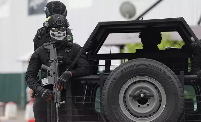 A soldier of the presidential guard stands on duty as the motorcade of France's President Emmanuel Macron and Gabon's President Brice Oligui Nguema drives past, in Libreville, Gabon, Monday, Nov. 24, 2025. (AP Photo/Thibault Camus)