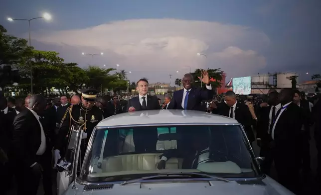 French President Emmanuel Macron, left, and Gabon's President Brice Oligui Nguema wave at the crowd before a meeting in Libreville, Gabon, Sunday, Nov. 23, 2025. (AP Photo/Thibault Camus)