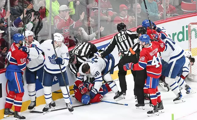 Players from the Montreal Canadiens and Toronto Maple Leafs fight during third period of an NHL hockey game in Montreal, Saturday, Nov. 22, 2025. (Graham Hughes/The Canadian Press via AP)