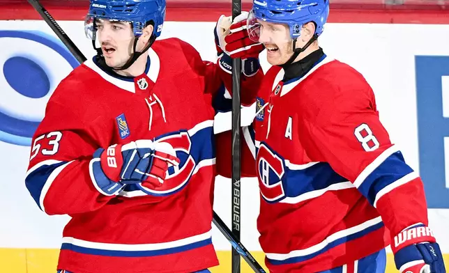 Montreal Canadiens' Noah Dobson (53) celebrates with teammate Mike Matheson (8) after scoring against the Toronto Maple Leafs during the first period of an NHL hockey game in Montreal, Saturday, Nov. 22, 2025. (Graham Hughes/The Canadian Press via AP)