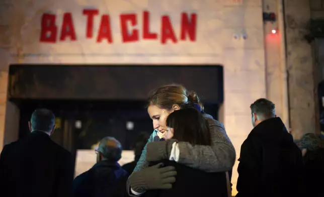 FILE - Women hug in front of the Bataclan concert hall in Paris on Nov. 13, 2016 . (AP Photo/Thibault Camus, File)