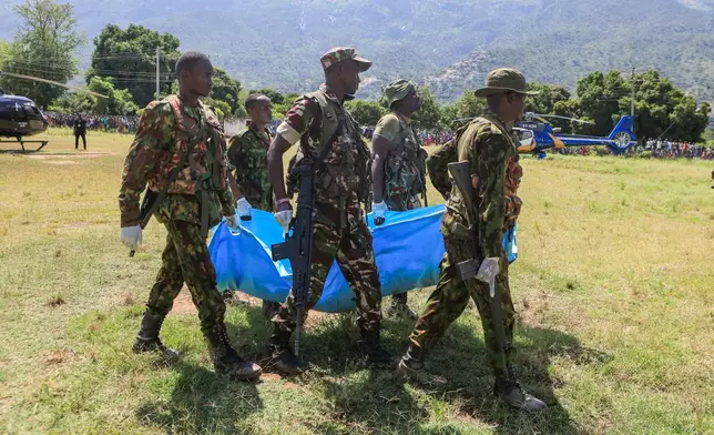 Rescue teams carry bodies of victims of a landslide in the hilly area of Chesongoch in Elgeyo Marakwet county, western Kenya, Sunday, Nov. 2, 2025. (AP Photo/Andrew Kasuku)