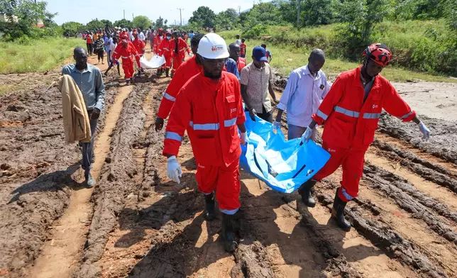 Rescue teams carry bodies of victims of a landslide in the hilly area of Chesongoch in Elgeyo Marakwet county, western Kenya, Sunday, Nov. 2, 2025. (AP Photo/Andrew Kasuku)