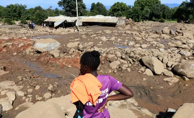 People inspect the scene of a landslide that killed scores in the hilly area of Chesongoch in Elgeyo Marakwet county, western Kenya, Sunday, Nov. 2, 2025. (AP Photo/Andrew Kasuku)